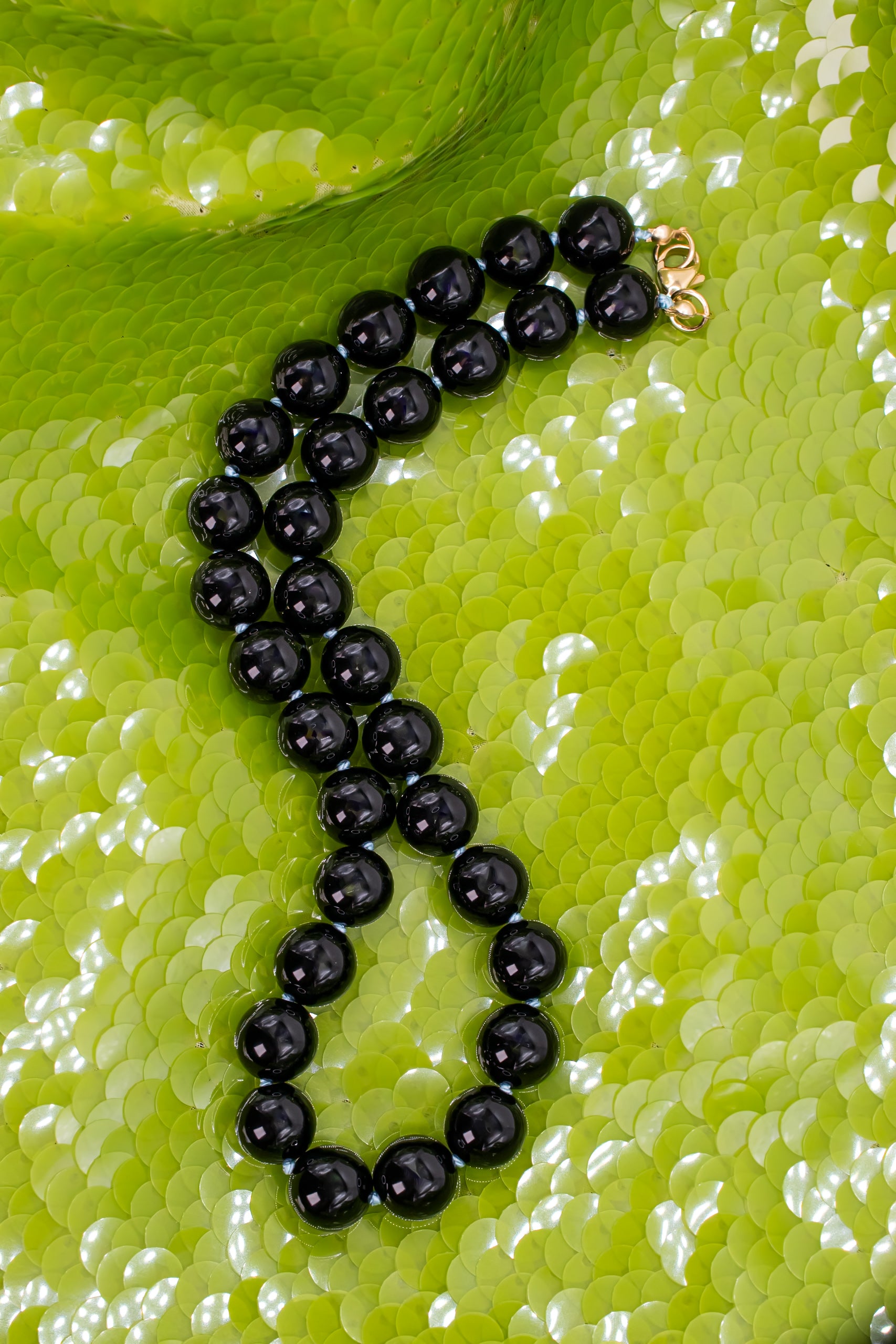 Black Onyx Silk Knotted Chunky Collar Necklace on vibrant green sequin background
